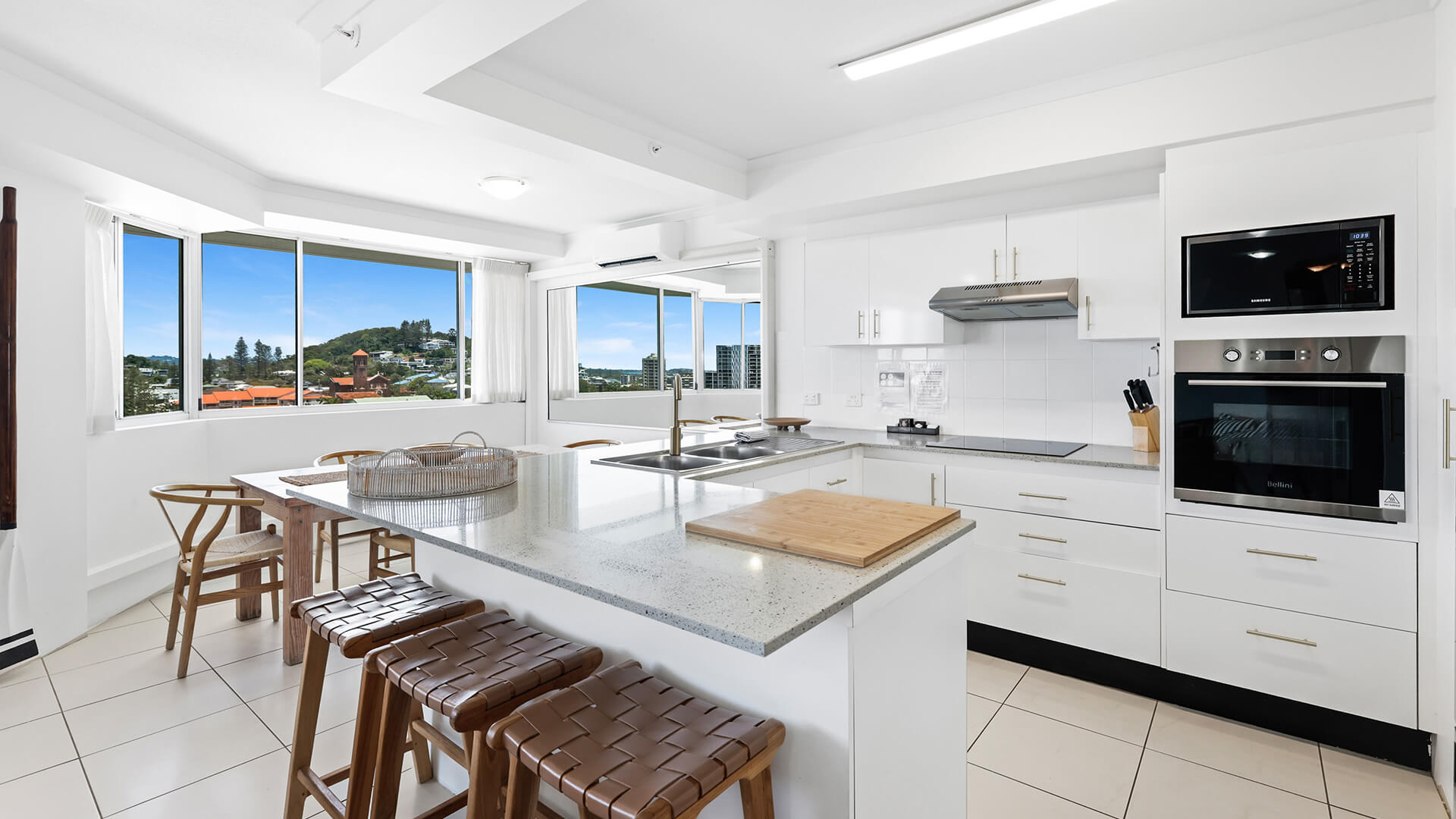 Modern kitchen and dining area in the 2 Bedroom Pool View Apartment at ULTIQA Points North with large windows and natural light.