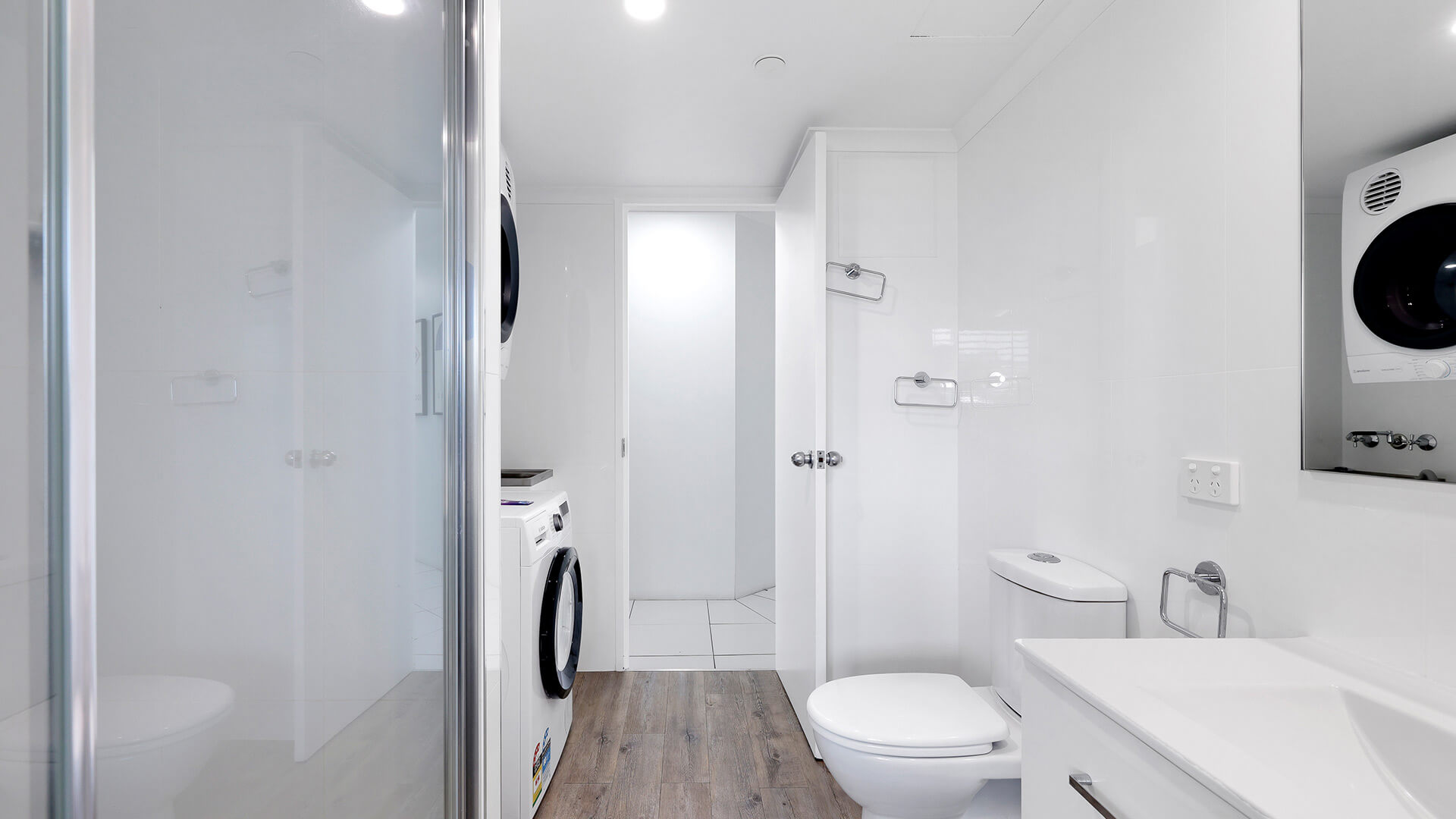 Bathroom with laundry facilities in the Superior 2 Bedroom Courtyard Apartment at ULTIQA Points North, featuring a shower and vanity.