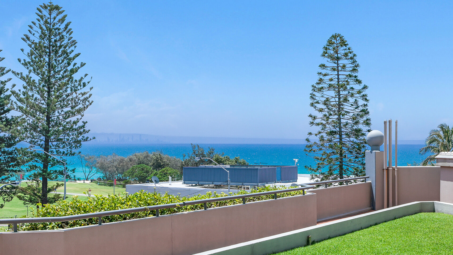 Courtyard ocean glimpse from the Superior 2 Bedroom Courtyard Apartment at ULTIQA Points North, overlooking greenery and the coastline.