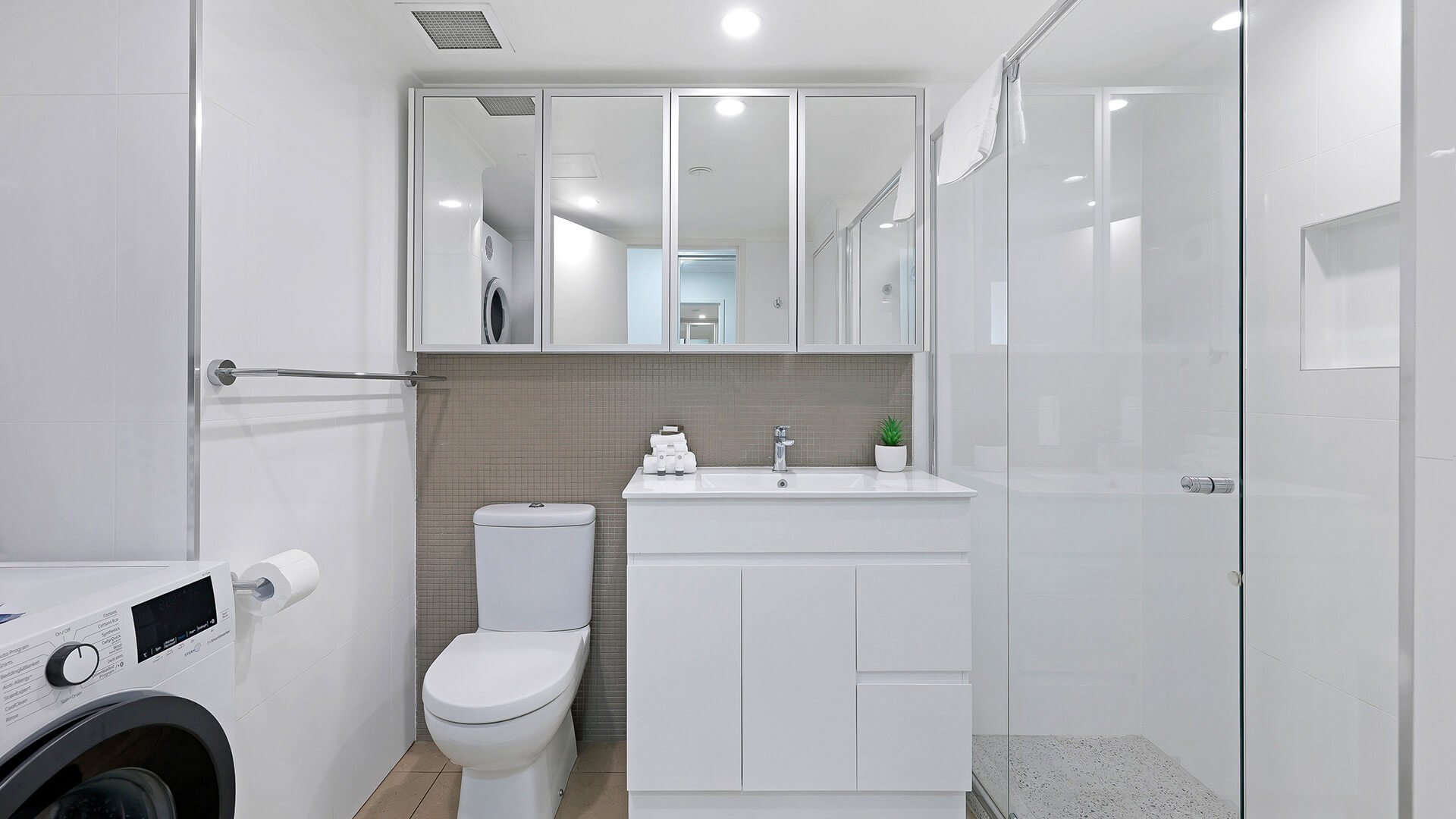Modern bathroom of the 2 Bedroom Superior Ocean View Apartment with shower, vanity, toilet, and laundry facilities.