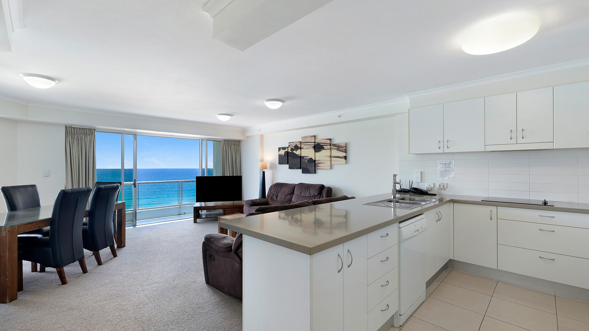 Open-plan kitchen, living, and dining area in the Deluxe 2 Bedroom Centre Front Apartment at ULTIQA Points North with direct ocean views.