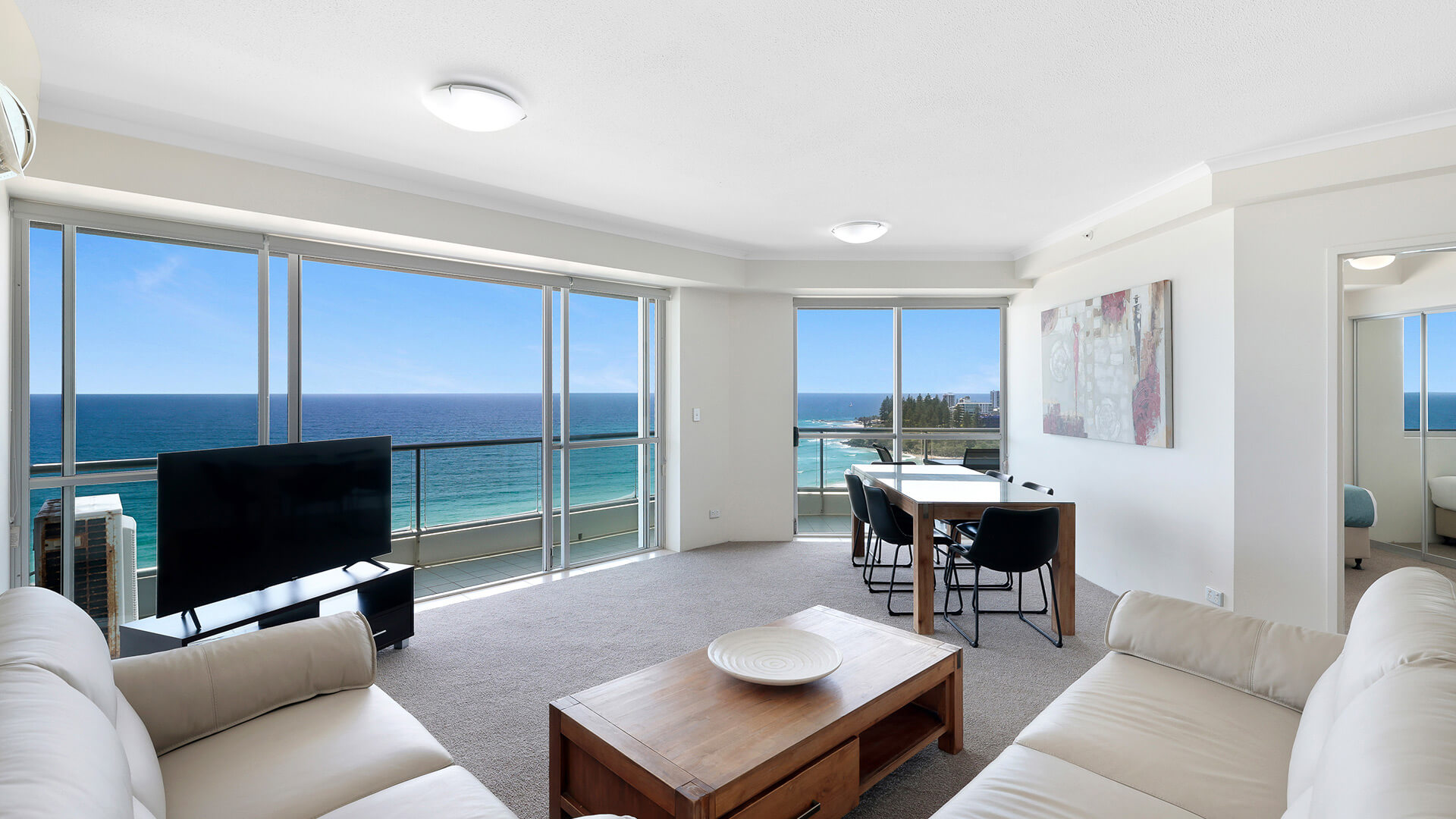 Bright oceanfront living and dining area in the Deluxe 2 Bedroom Centre Front Apartment at ULTIQA Points North.