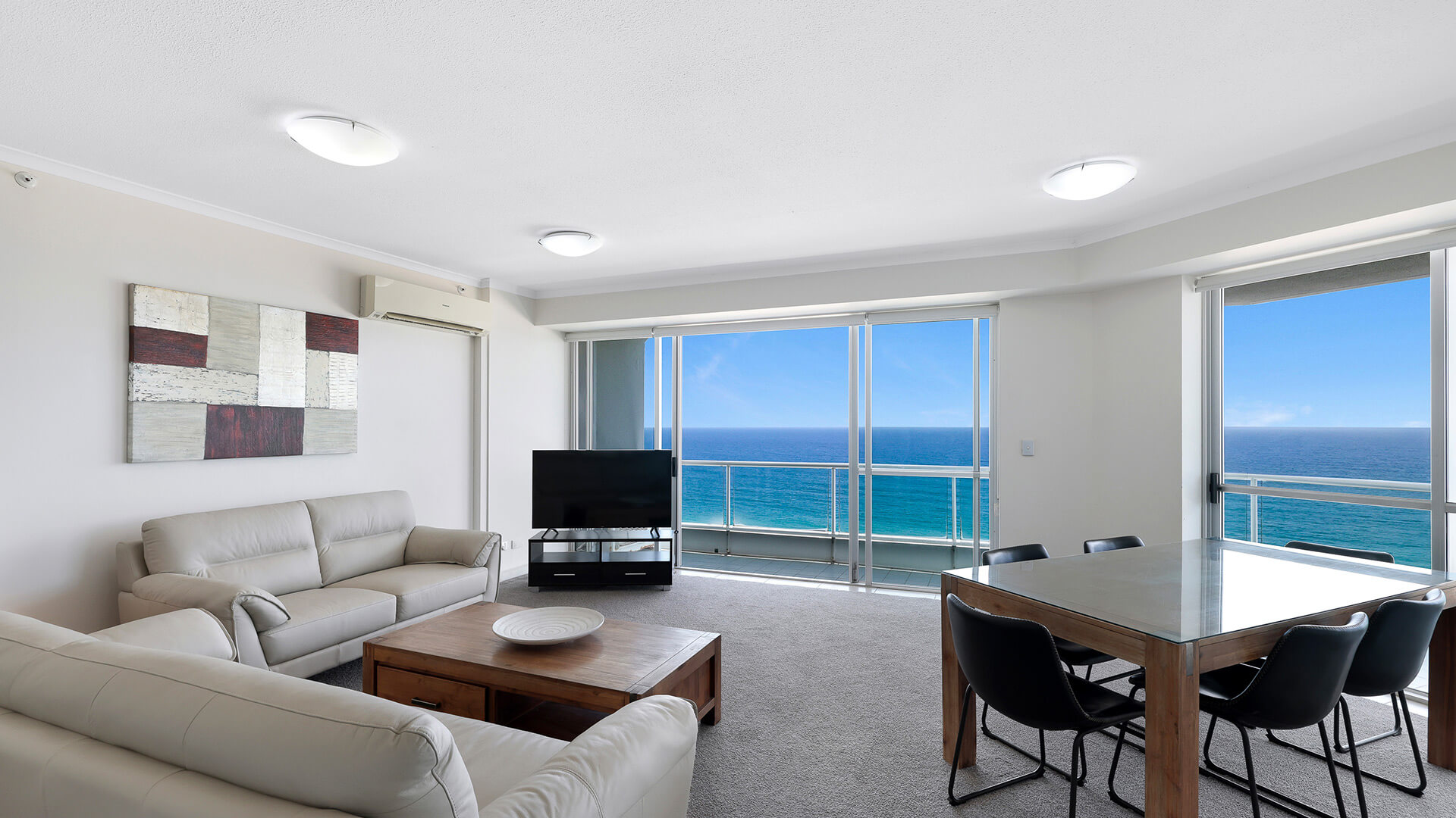 Ocean-view living and dining area in the Deluxe 2 Bedroom Centre Front Apartment at ULTIQA Points North.
