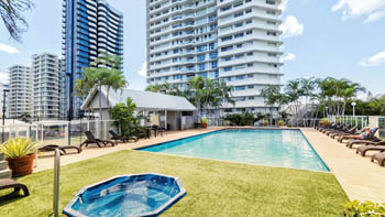 Outdoor pool and spa facilities at ULTIQA Points North with sun loungers and surrounding high-rise views.