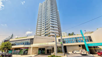 Street-level view of ULTIQA Points North Coolangatta, showcasing the tall white apartment tower above the retail and reception level on Marine Parade.
