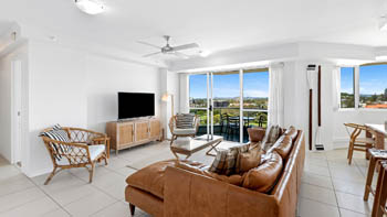 Living area in the 2 Bedroom Pool View Apartment at ULTIQA Points North with modern seating, TV, and balcony views.