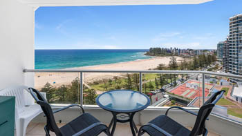 Private balcony in the 2 Bedroom Superior Ocean View Apartment with outdoor seating overlooking Coolangatta Beach and ocean views toward Rainbow Bay.
