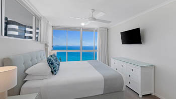 Bright master bedroom in the Superior 3 Bedroom Ocean View Apartment featuring queen bed, soft coastal décor and sweeping ocean views.