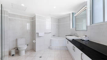 Bathroom in the 4 Bedroom Oceanfront Penthouse at ULTIQA Points North with spa bath, walk-in shower, and long vanity.