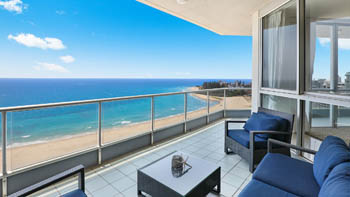 Outdoor seating area on the balcony of the 4 Bedroom Oceanfront Penthouse at ULTIQA Points North with beach and ocean views.