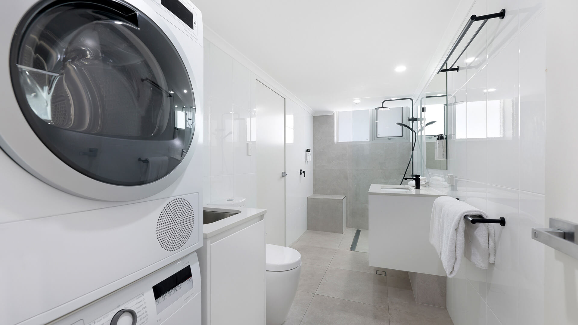 Spacious bathroom with washer and dryer plus walk-in shower at ULTIQA Beach Haven, Gold Coast accommodation