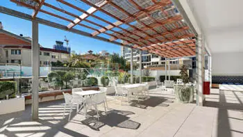 Guest BBQ and recreation area at ULTIQA Beach Haven on Broadbeach featuring a tiled island bench, bar seating, modern cooking facilities, and built-in lounge seating ideal for casual outdoor dining.