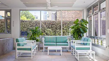 Indoor relaxation lounge at ULTIQA Beach Haven on Broadbeach featuring modern coastal seating, lush indoor plants, and natural light - perfect for unwinding poolside.