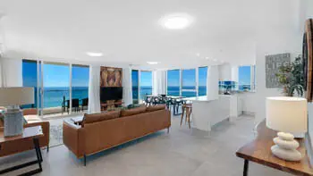 Spacious open-plan unit featuring leather lounges, a modern kitchen, ocean-facing dining area, and stunning uninterrupted coastal. 