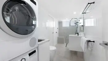 Bathroom featuring a walk-in shower and dual vanity.
