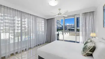 Bedroom with king bed, ceiling fan and balcony access in the 2 Bedroom Apartment at ULTIQA Beach Haven on Broadbeach.