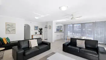 Open living space with black leather couches and natural light in the 2 Bedroom Apartment at ULTIQA Beach Haven on Broadbeach.