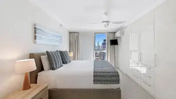 Master bedroom in the 2 Bedroom Ocean View Apartment at ULTIQA Beach Haven on Broadbeach with king bed, built-in wardrobe, and city views.