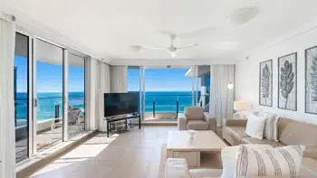 Light-filled living room in the 2 Bedroom Ocean View Apartment at ULTIQA Beach Haven on Broadbeach with coastal décor, comfortable leather seating, and uninterrupted ocean views through floor-to-ceili