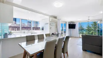 Open-plan kitchen, dining, and living area in the 2 Bedroom Ocean View Apartment at ULTIQA Beach Haven on Broadbeach with ocean views and balcony access.