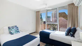 Second bedroom in the 2 Bedroom Ocean View Apartment at ULTIQA Beach Haven on Broadbeach with two single beds and large window.