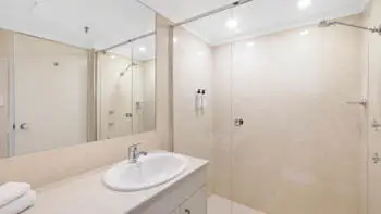 Second bathroom in the 2 Bedroom Ocean View Apartment at ULTIQA Beach Haven on Broadbeach with shower over bath and modern vanity.