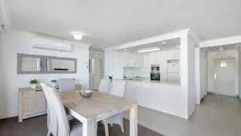 Open-plan kitchen and dining area in the 2 Bedroom Ocean View Apartment at ULTIQA Beach Haven on Broadbeach with modern appliances and coastal-style furnishings.