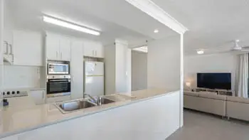 Kitchen in the 2 Bedroom Ocean View Apartment at ULTIQA Beach Haven on Broadbeach with double sink, built-in oven, and open layout to living area.