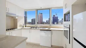 Fully equipped kitchen with city views in the Standard 2 Bedroom Ocean View Apartment at ULTIQA Beach Haven on Broadbeach.