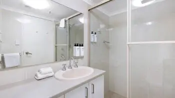 Bathroom in the Standard 2 Bedroom Ocean View Apartment at ULTIQA Beach Haven on Broadbeach featuring a walk-in shower and vanity.