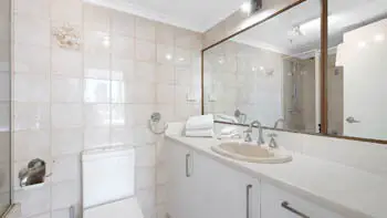 Bathroom in the Standard 2 Bedroom Ocean View Apartment at ULTIQA Beach Haven on Broadbeach with a large vanity, wall mirror, and shower-over-bath combo.