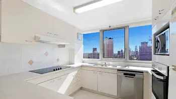 Fully equipped kitchen with city skyline views in the Standard 2 Bedroom Ocean View Apartment at ULTIQA Beach Haven on Broadbeach.