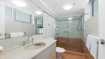 Bathroom in the Standard 2 Bedroom Ocean View Apartment at ULTIQA Beach Haven on Broadbeach, featuring a spacious walk-in shower, vanity, and large mirror.