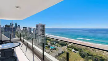 Private balcony with panoramic Gold Coast skyline and beach, complete with outdoor table and chairs.