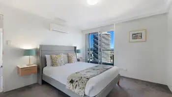 Main bedroom featuring a king bed, air-conditioning, private balcony access, and views over Broadbeach.