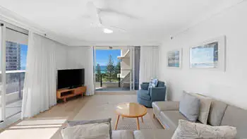 Bright and airy living featuring a modern lounge suite, flat-screen TV, and private balcony with ocean views.