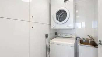 In-apartment laundry with washer, dryer and sink at ULTIQA Beach Haven on Broadbeach, Surfers Paradise.