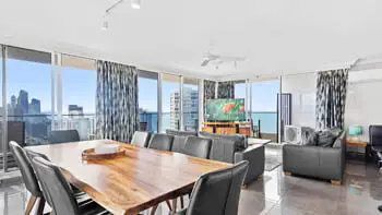 Dining room with living area in the background and views of the Gold Coast at ULTIQA Beach Haven on Broadbeach.