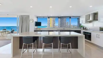 Modern kitchen with island bench and skyline views in the Sub Penthouse at ULTIQA Beach Haven on Broadbeach.