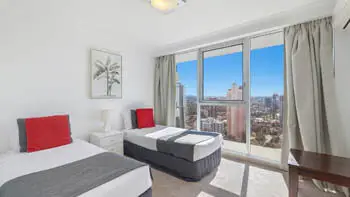 Twin bedroom in the Sub Penthouse at ULTIQA Beach Haven on Broadbeach, featuring floor-to-ceiling windows and city views.