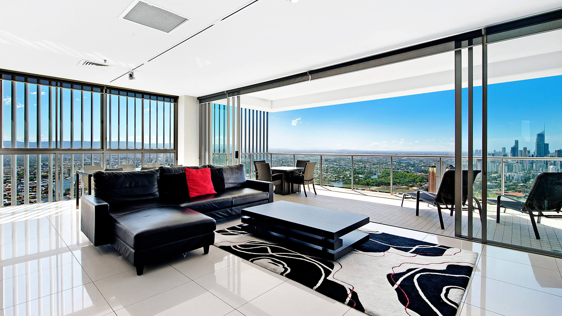 Open-plan lounge and dining with panoramic skyline and hinterland views from 2 Bedroom Gold Coast View Suite at ULTIQA Air on Broadbeach.