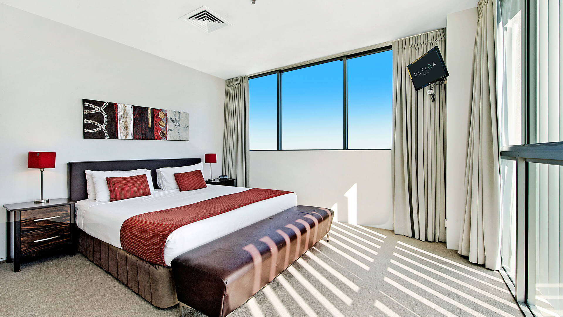 Bright and inviting master bedroom with king bed, private TV, and modern décor in the 2 Bedroom Gold Coast View Suite at ULTIQA Air on Broadbeach.