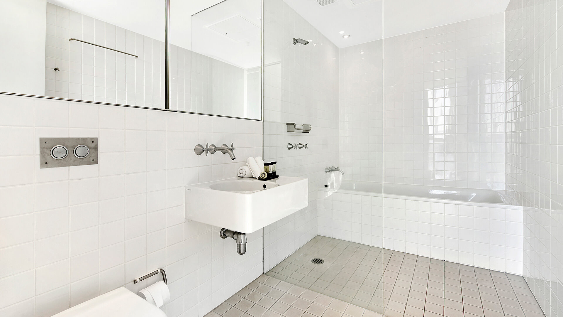 Modern bathroom with glass-enclosed shower and bathtub in the 2 Bedroom Gold Coast View Suite at ULTIQA Air on Broadbeach.