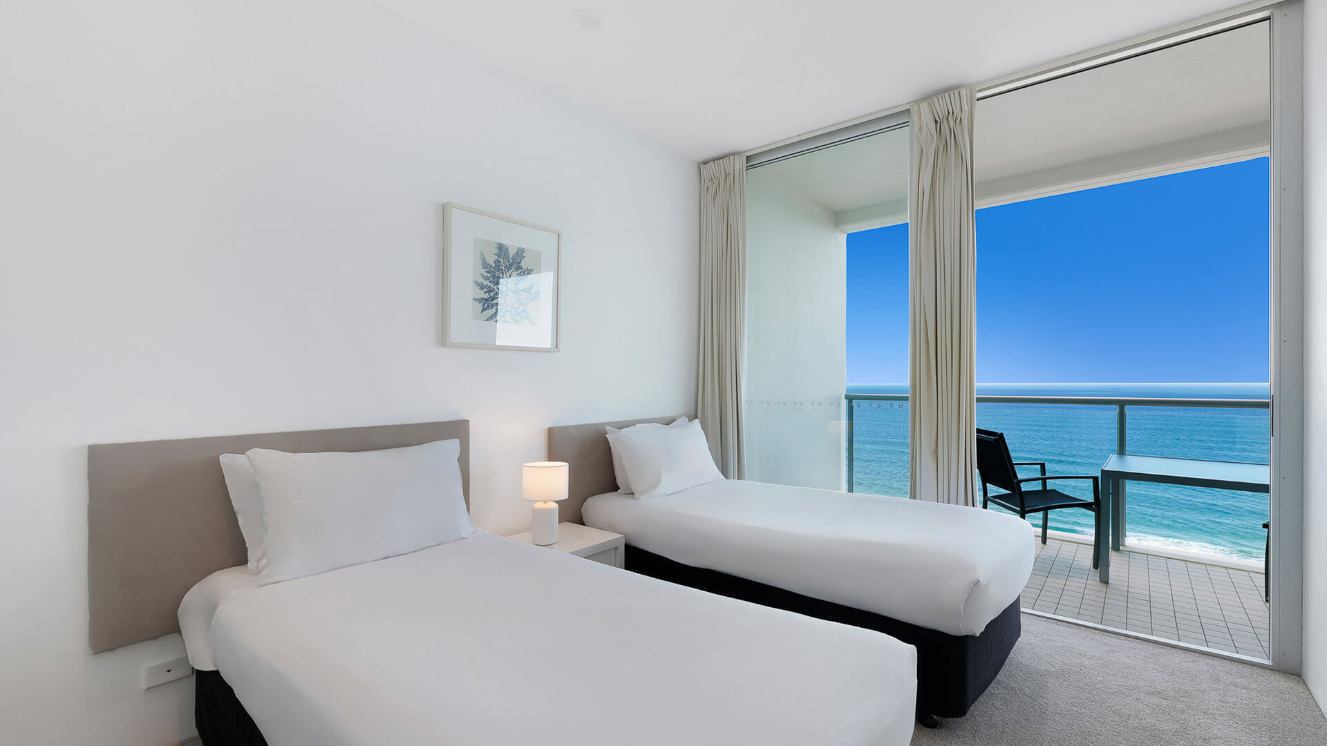 Twin bedroom with ocean views and balcony access in the 2 Bedroom Ocean View Apartment at ULTIQA Air on Broadbeach.