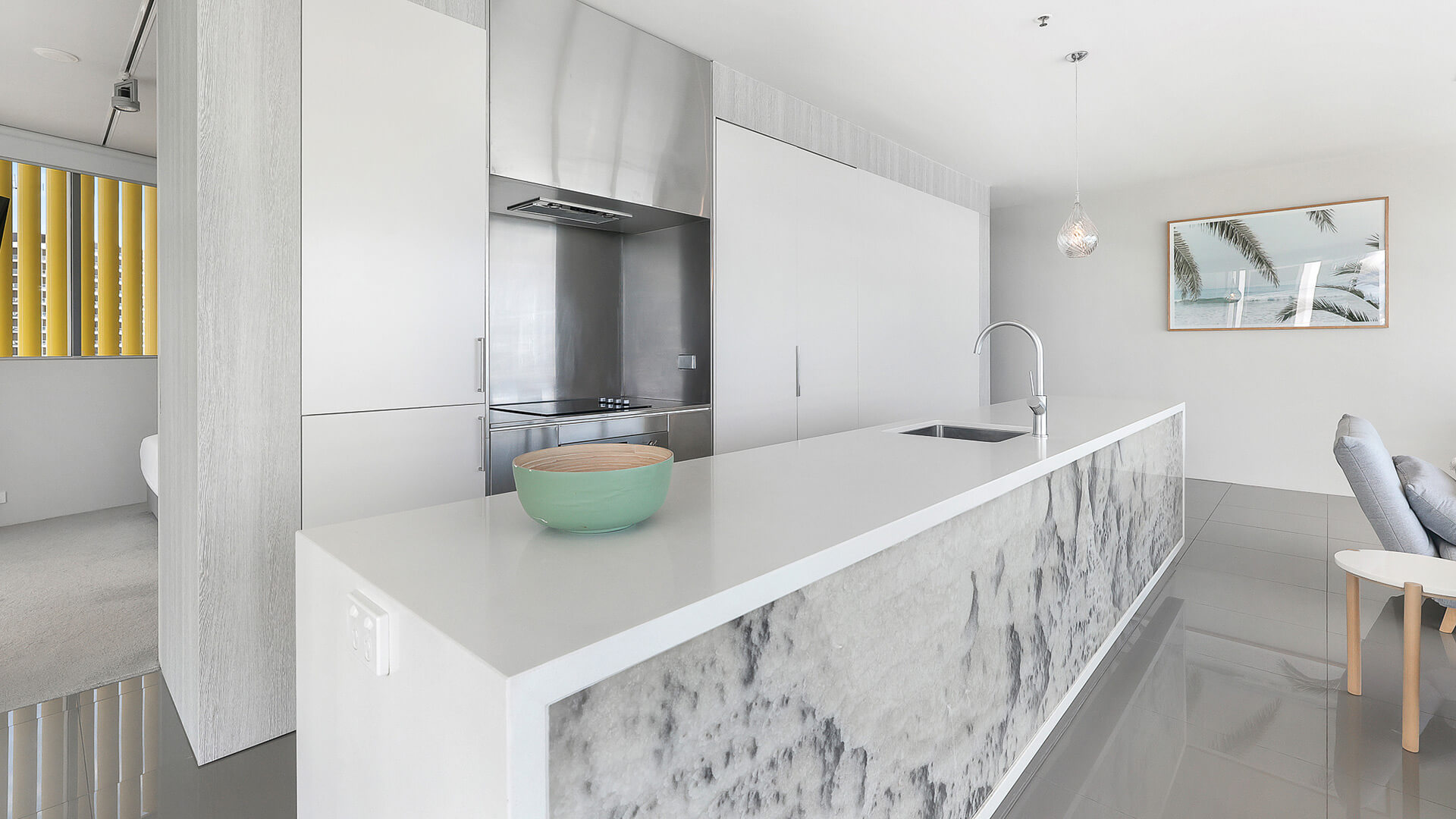 Modern kitchen with sleek island bench and integrated appliances in 2 Bedroom Ocean View Suite at ULTIQA Air on Broadbeach.