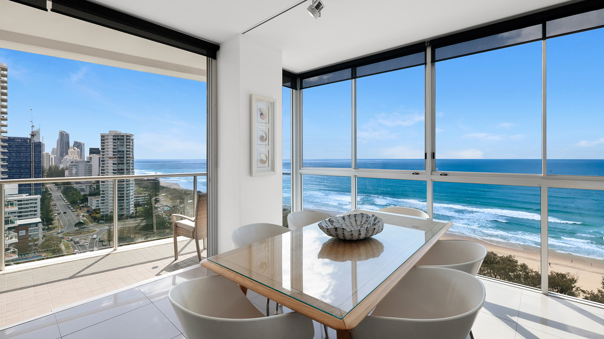 Ocean-facing dining area with glass windows and balcony in 3 Bedroom Apartment at ULTIQA Air on Broadbeach.