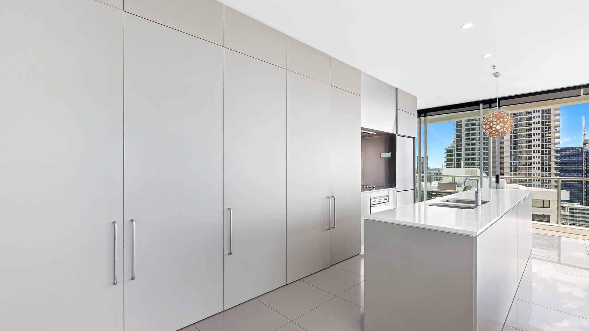 Modern kitchen in 3 Bedroom Ocean View Apartment at ULTIQA Air on Broadbeach with island bench and city views.