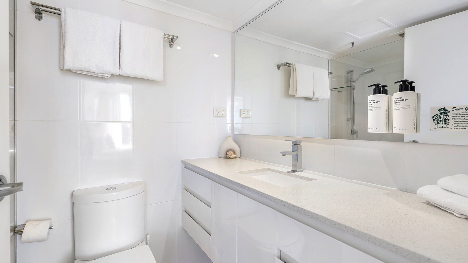 Modern bathroom in the 2 Bedroom Ocean View Apartment at ULTIQA Beach Haven featuring a large vanity, walk-in shower, and complimentary toiletries.