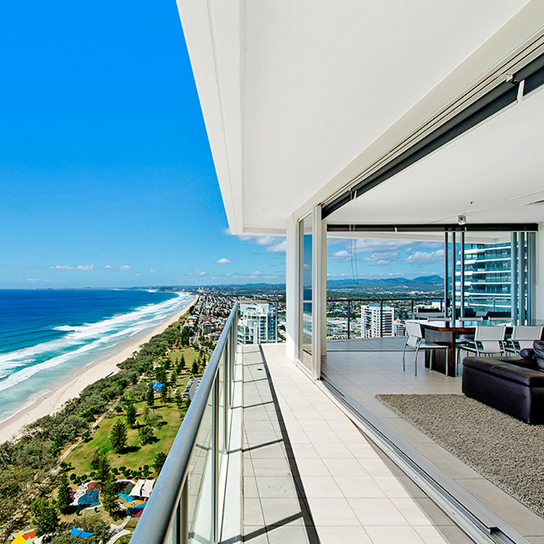 Spacious beachfront apartment balcony at ULTIQA Air on Broadbeach with panoramic ocean views, outdoor dining, and open-plan living overlooking the Gold Coast coastline