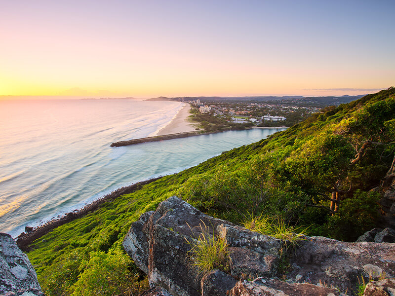 Scenic sunrise view from Burleigh Headland overlooking the coastline and ocean.
